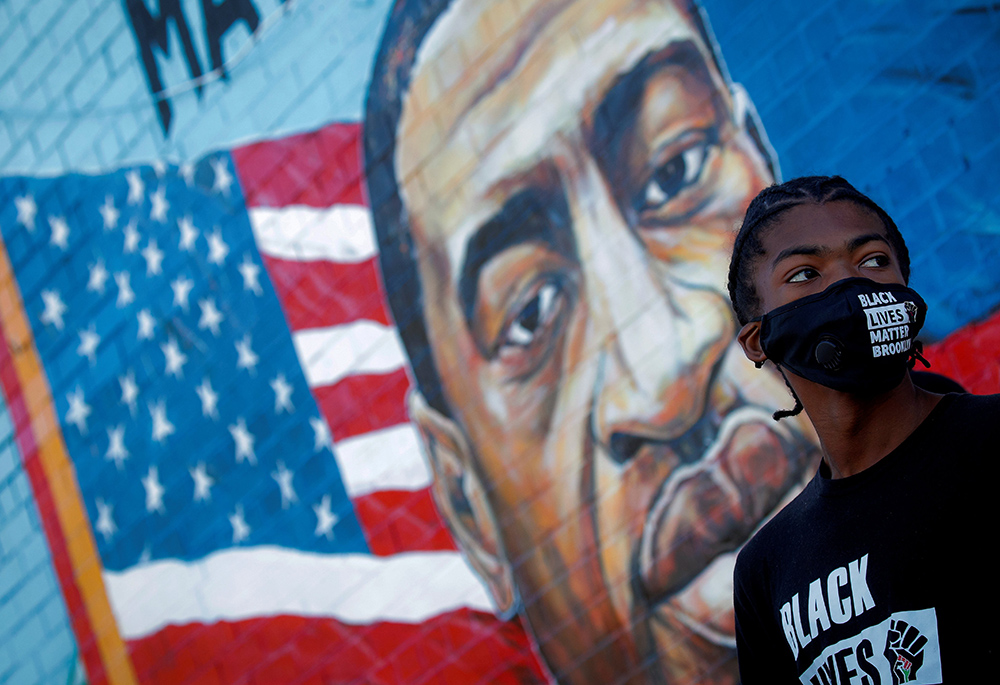 A person in the Brooklyn borough of New York City attends a birthday vigil for George Floyd Oct. 14, 2020; Floyd died at the hands of a white Minneapolis police officer May 25, 2020. Black Catholics told NCR that current realities pertaining to racism demand a deeper commitment from the U.S. bishops. (CNS/Reuters/Brendan McDermid)