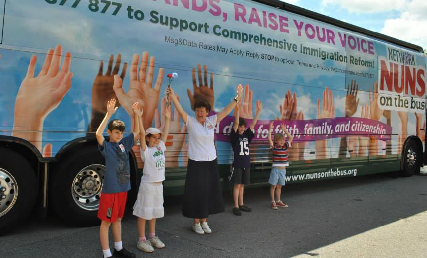 La Hna. Mary Ellen Lacy a un lado del autobús de la Network Lobby durante la gira de 2013 de Monjas en el Bus por la reforma migratoria. Lacy comenzó su carrera como enfermera y más tarde se unió a las Hijas de la Caridad. Ahora es abogada de inmigración. (Foto: cortesía Mary Ellen Lacy)