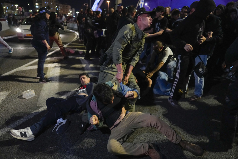 Police drag Israeli protesters through street in Jerusalem. 