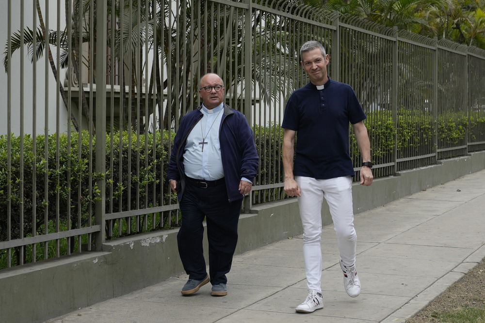 Two clerics walk down sidewalk