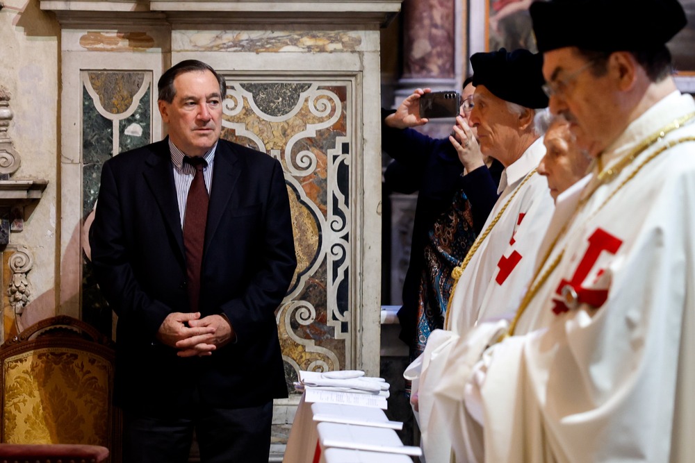 Donnelly stands, hand folded, as prelates say Mass. 