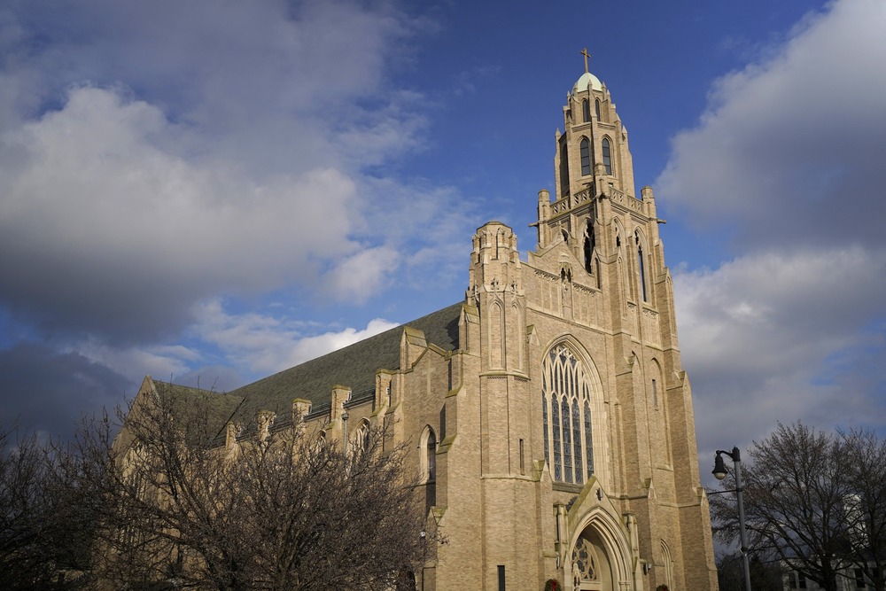 Cathedral's spire against clouded sky. 