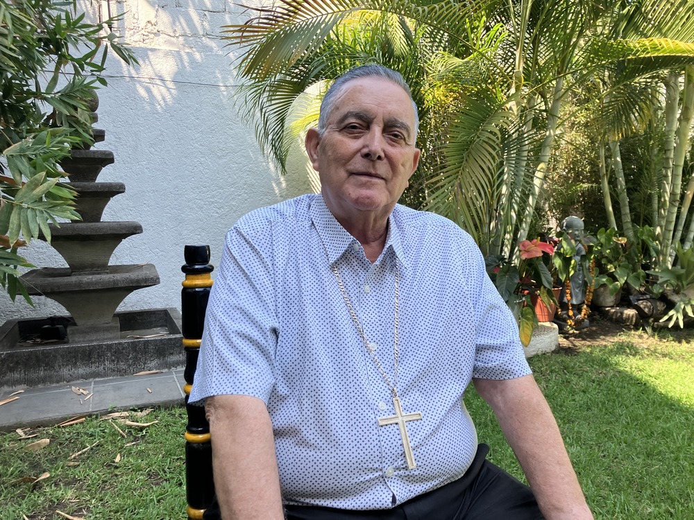 Casual portrait of bishop sitting in garden. 