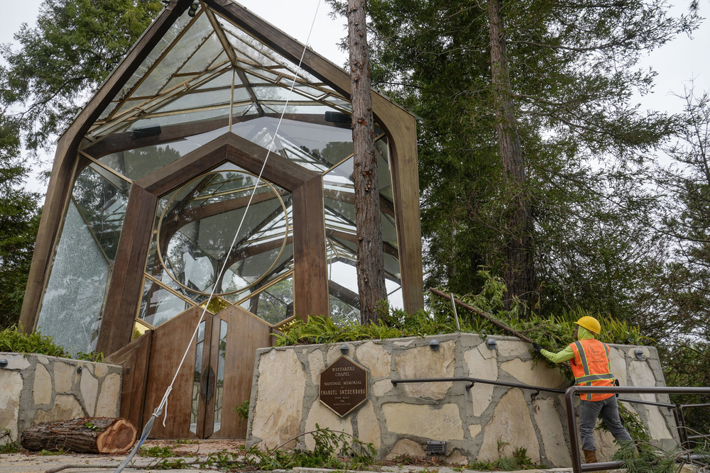 Wayfarer Chapel, Southern California, landslide. Chapel seen amidst trees, maintenance worker seen in bottom right corner.