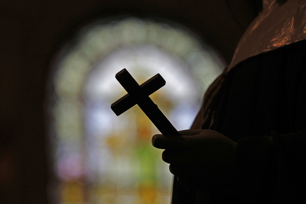 Archdiocese of New Orleans, search warrant, sex abuse Image of a crucifix silhouetted against a stained glass window.