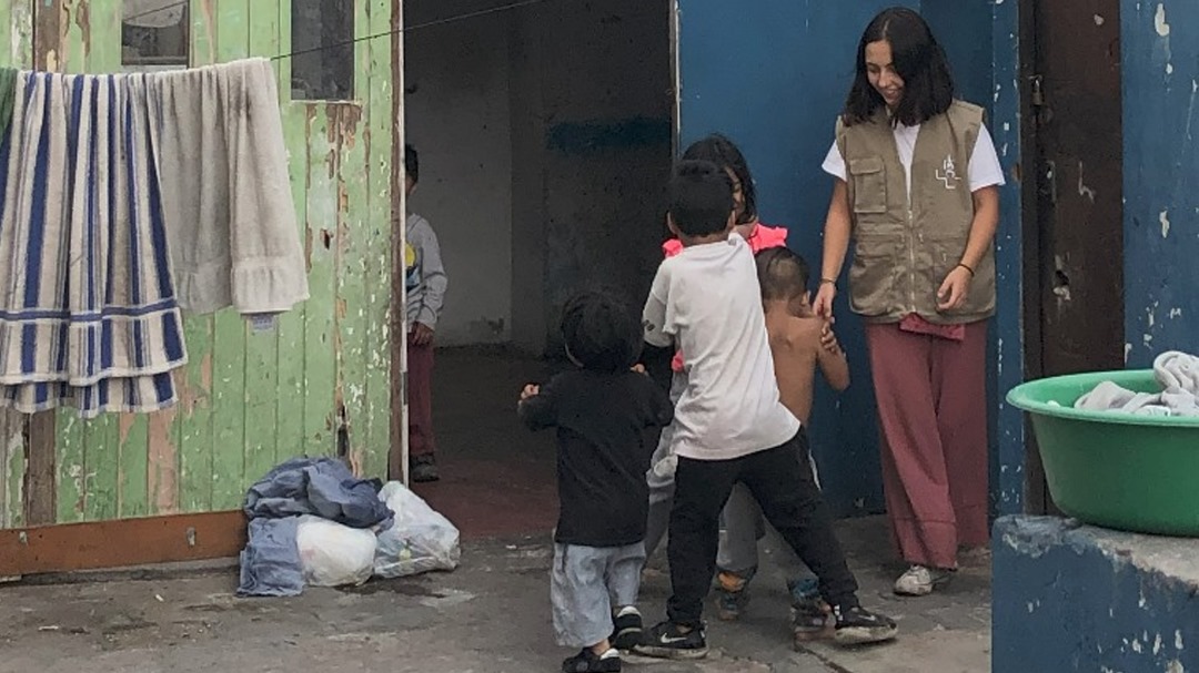 A social ministry volunteer plays with children during a visit to a family in Lima (Begoña Costillo)