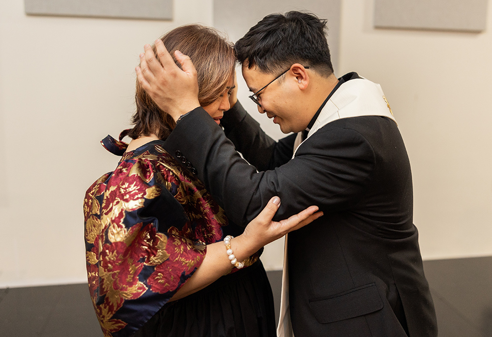 Paulist Fr. Dan Macalinao blesses his mother during his ordination Mass on May 18. (Courtesy of Zachera Wollenberg)