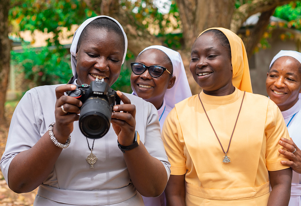 Handmaids of the Holy Child Jesus Sr. Emmanuella Dakurah (holding camera), Sisters of Mary Immaculate Sr. Juliana Atuuna, Daughters of the Most Holy Trinity Sr. Patricia Akoto, and Sisters of Mary Immaculate Sr. Gloria Duongnaa practice using a camera at a training session May 9 at Santasi in Ghana's Kumasi Archdiocese. (Newswatchgh.com/Damian Avevor)