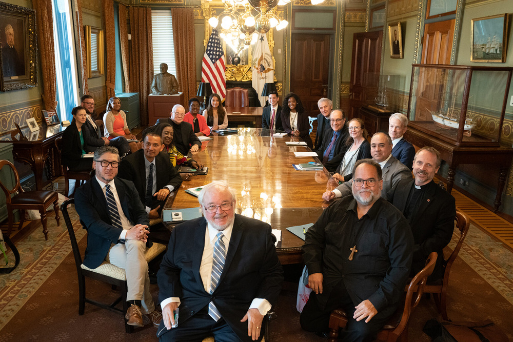 Groups sits in circle around large conference table