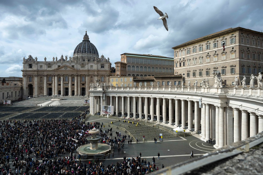 Wide view of St. Peter's Square, with large crowd gathered before the colonnade