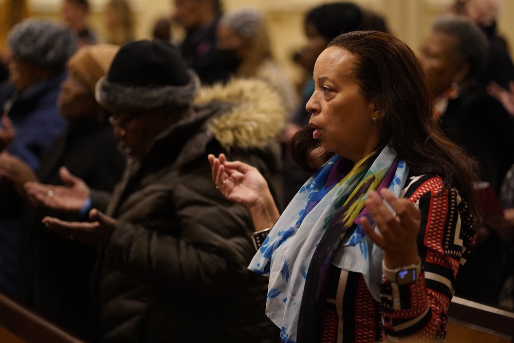 Black liturgy conference People raise their hands in prayer