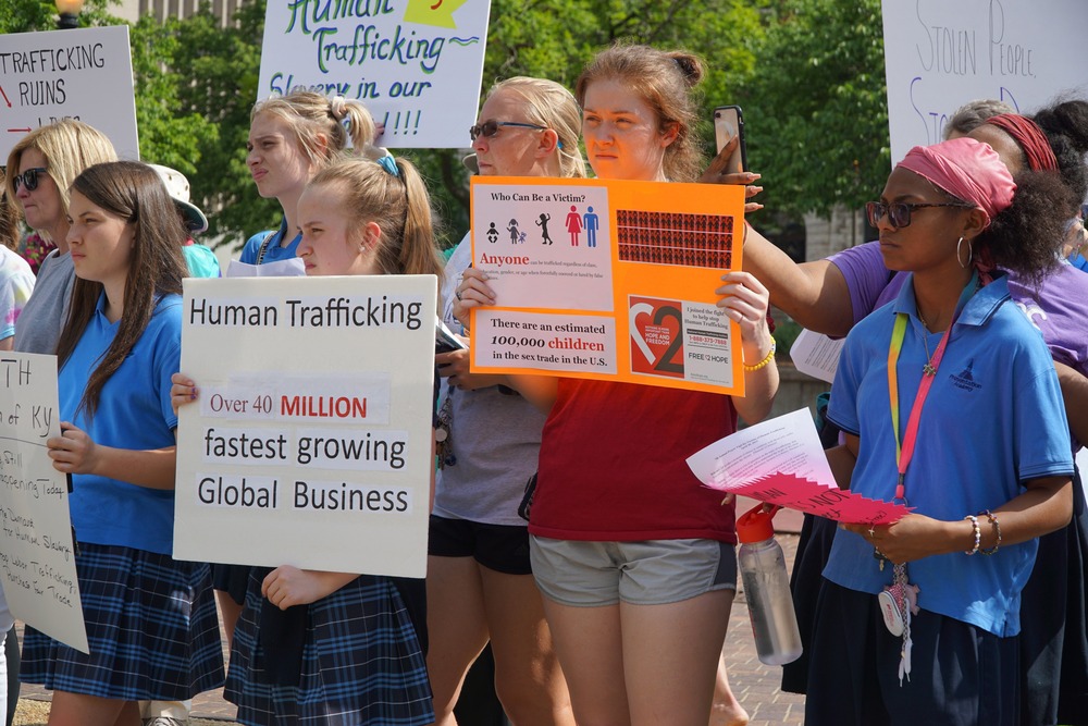 Young people demonstrate with signs in favor of combating human trafficking 