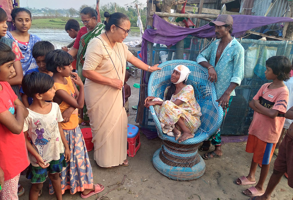 Sr. Minita Chisim, the superior of the Bagerhat convent of Our Lady of the Missions Sisters, visits Niva Halder of Mariapolli village, who was injured by a storm on April 9. (Courtesy of Sr. Sukriti B. Gregory)