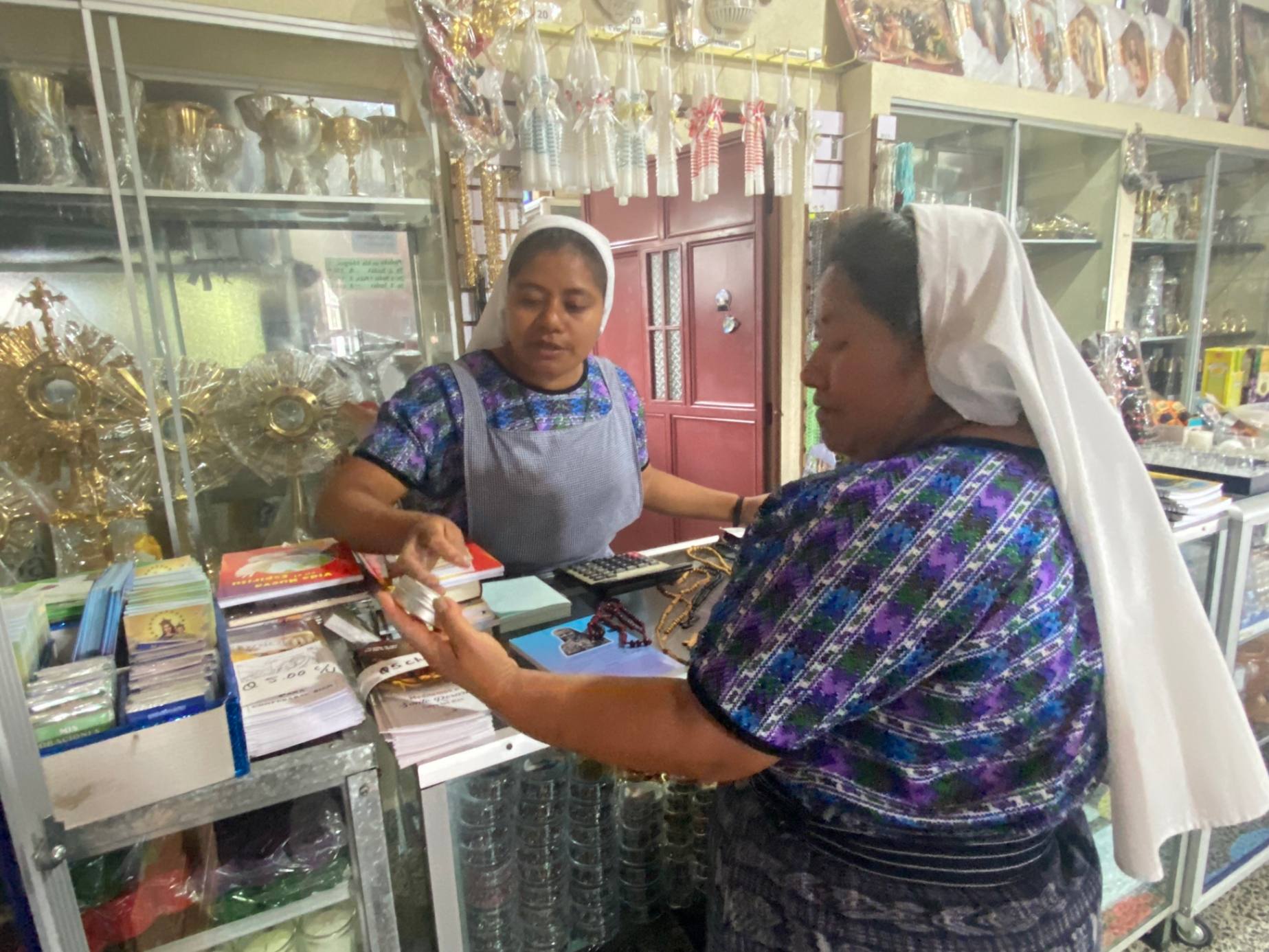 Sr. Juana Toma Perez shows Sr. Marta Yach Cosme an ointment made from natural ingredients at a store run by the Missionary Sisters of the Eucharist in San Andres Semetabaj, Guatemala, Aug. 22, 2023. Some sisters have knowledge of the medicinal benefits of plants or massage as alternative medicine, which helps them serve the Indigenous peoples of the region. (GSR photo/Rhina Guidos)