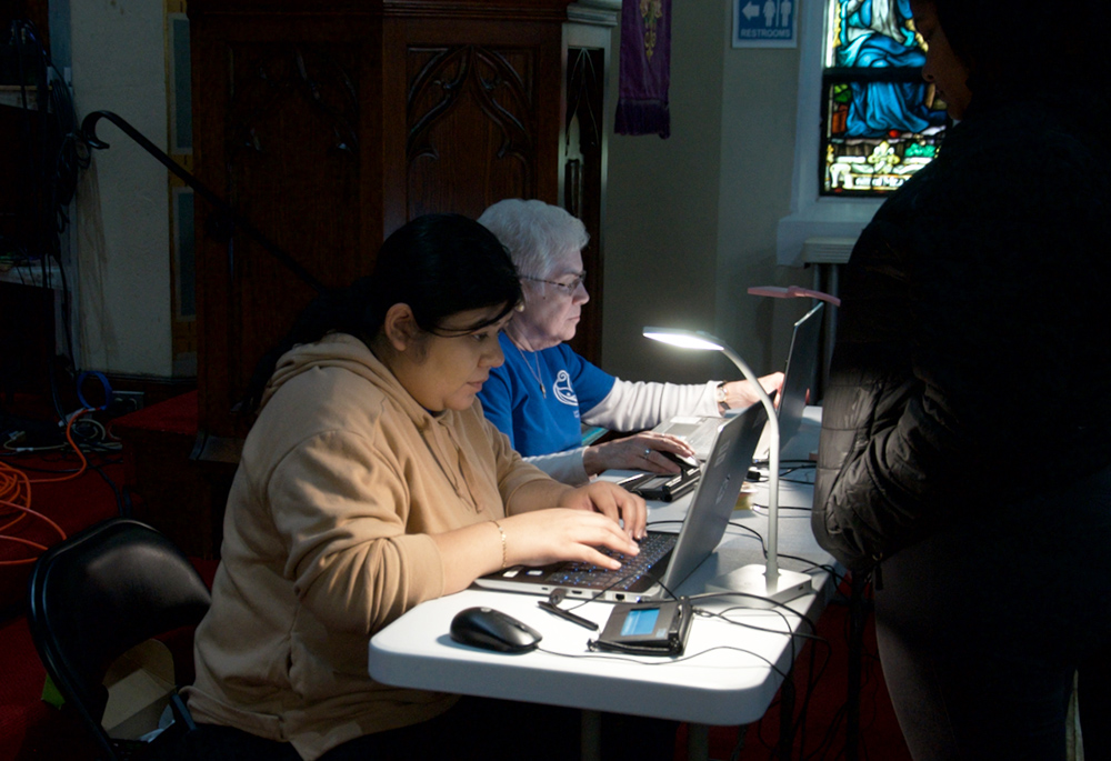 Volunteers register neighbors to go through the food line at the SSJ Neighborhood Center in Camden, New Jersey, during the center's monthly food distribution day on March 20. (GSR photo/Dan Stockman)