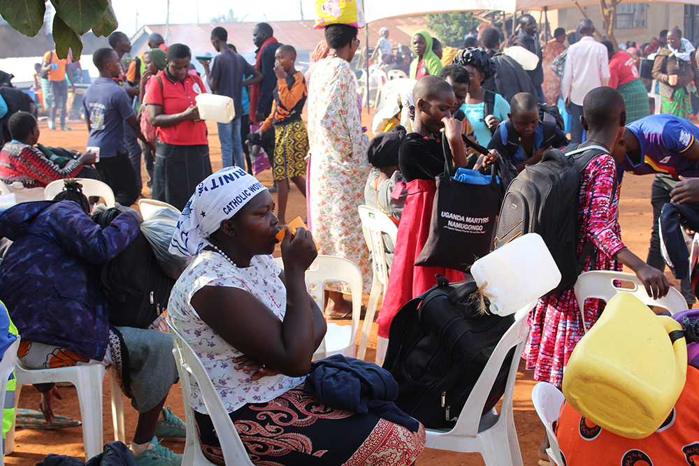 Catholics enjoy a cup of porridge after trekking for hundreds of miles and finally reaching the Catholic Martyrs' Shrine of Namugongo in Kampala, Uganda's capital, to honor the 22 Catholic and 23 Anglican martyrs burned alive between 1885 and 1887 on stern orders of Kabaka Mwanga II, then the king of Buganda. They also carry jerricans to fill in holy water from the Mukajanga well, which is believed to cure all kinds of illnesses. (GSR photo/Gerald Matembu)