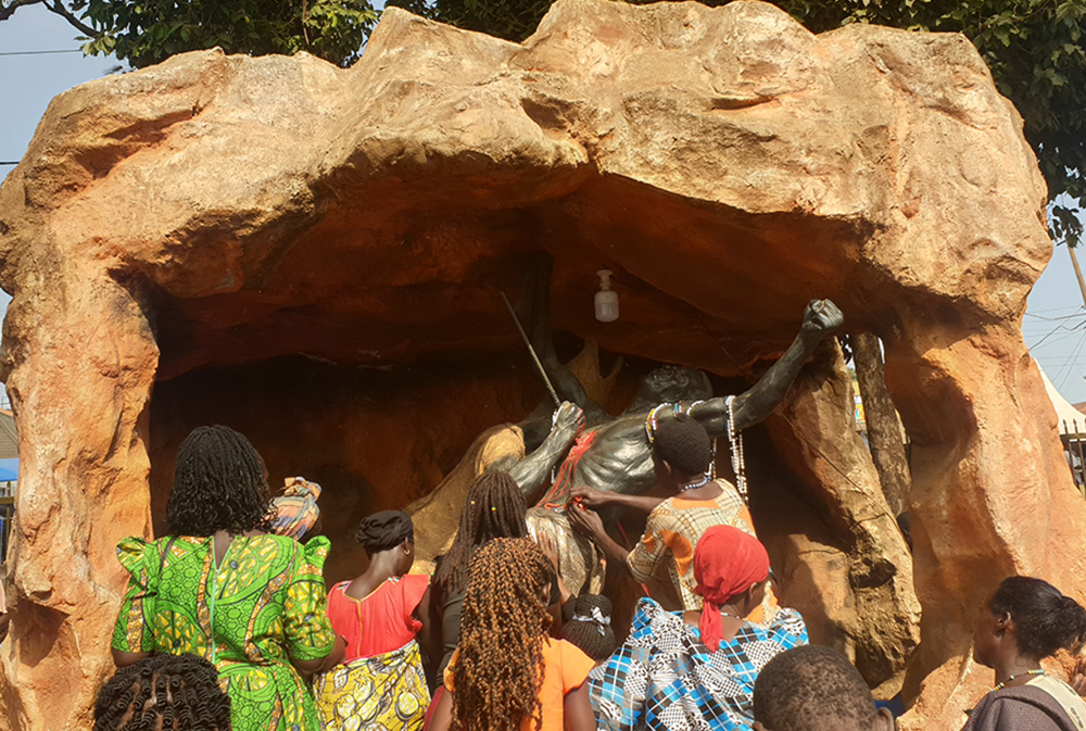 Pilgrims kneel before Uganda Martyrs' statues in Namugongo in Kampala, Uganda's capital, praying hours to commemorate Martyrs' Day on June 3, 2024. (GSR photo/Gerald Matembu)