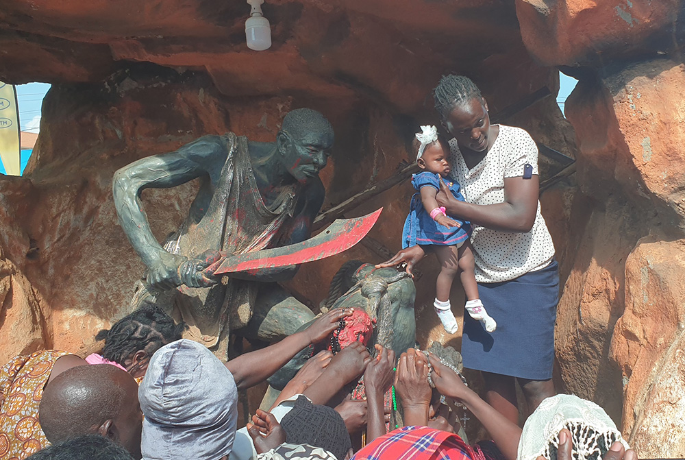 A woman carries her sick child and presents her before Uganda Martyrs' statues in Namugongo in Kampala, Uganda's capital, as she prays for her healing before joining the Mass to commemorate the 45 Catholic and Anglican martyrs who were killed on the orders of Kabaka Mwanga II in the late 1880s. (GSR photo/Gerald Matembu)