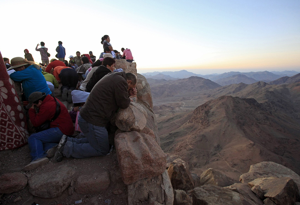 Worshippers pray outside a church on the summit of Mount Sinai during sunrise in the Sinai Peninsula July 23, 2010. (CNS/Reuters/Goran Tomasevic)