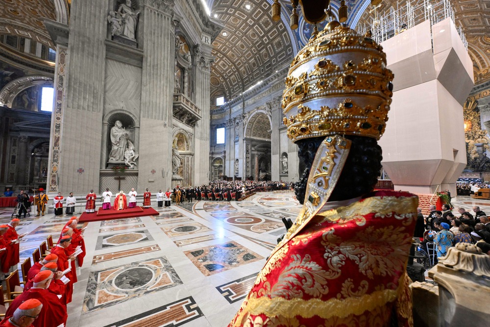 Bronze statue of St. Peter, adorned with Papal regalia, pictured from behind, Pallium Mass fills frame