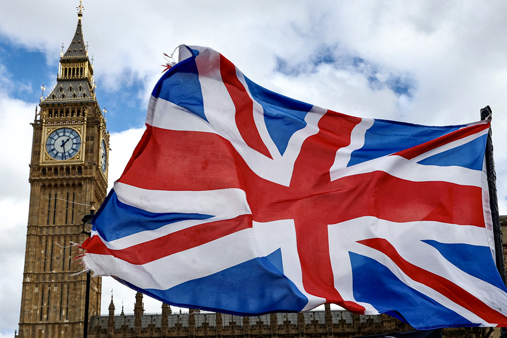 A Union Jack flag flutters in the wind near Big Ben and Parliament in Parliament Square in London March 29. (OSV News/Reuters/Kevin Coombs)