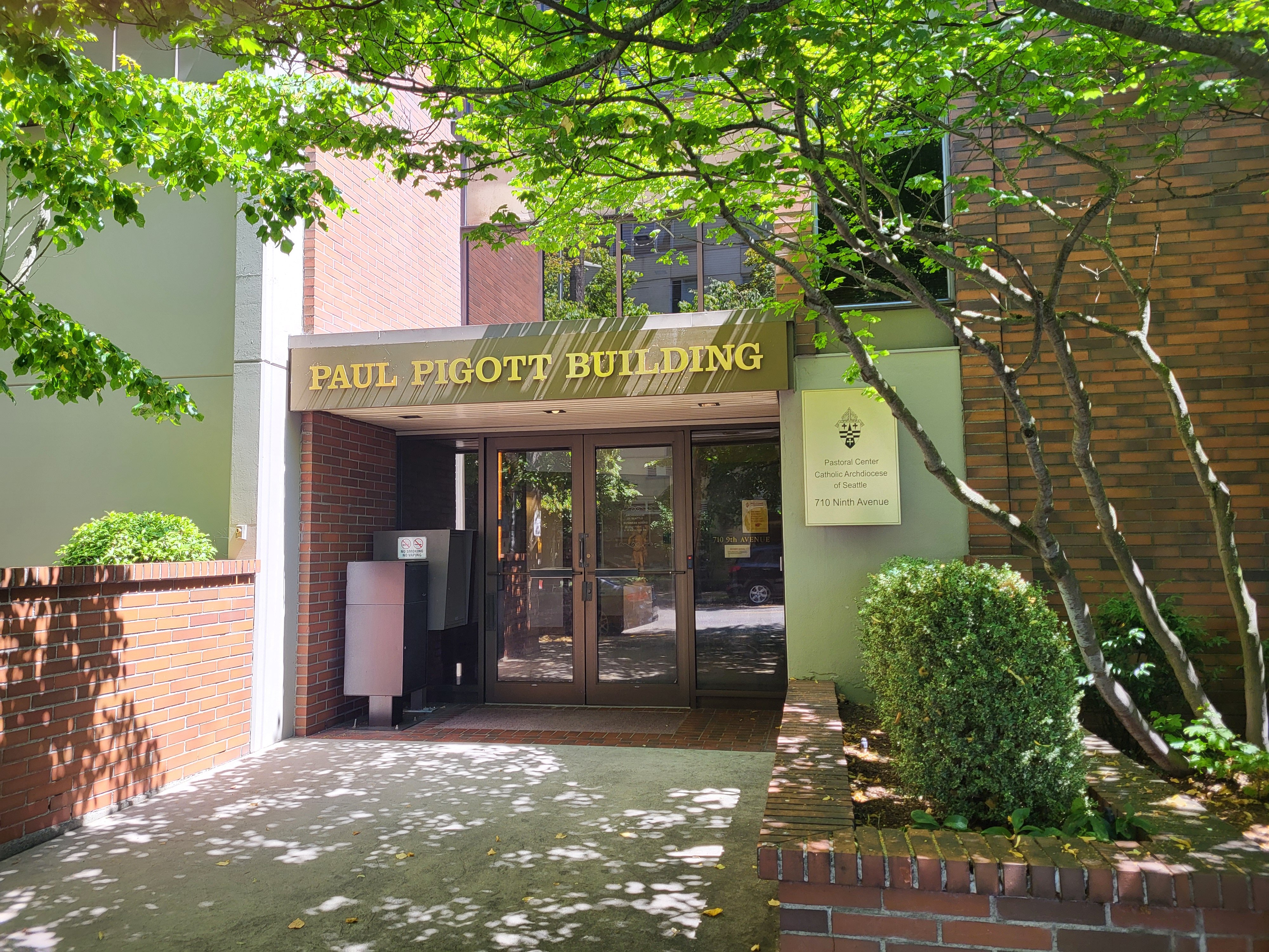 Entrance to building framed by tree. 