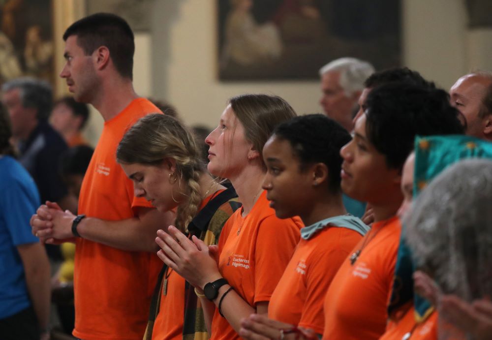 Shayla Elm, a perpetual pilgrim with the Juan Diego Route (center looking up), prays alongside others from her group while attending a Mass to welcome pilgrims at St. John the Evangelist Church in Indianapolis July 16. Shayla Elm, a perpetual pilgrim with the Juan Diego Route (center looking up), prays alongside others from her group while attending a Mass to welcome pilgrims at St. John the Evangelist Church in Indianapolis July 16.