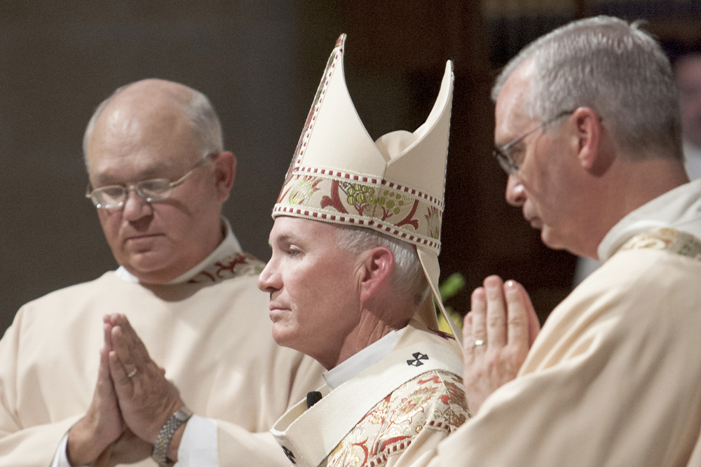 Archbishop George Lucas of Omaha, Nebraska. Archbishop Lucas, vested, says Mass. Pictured in profile.