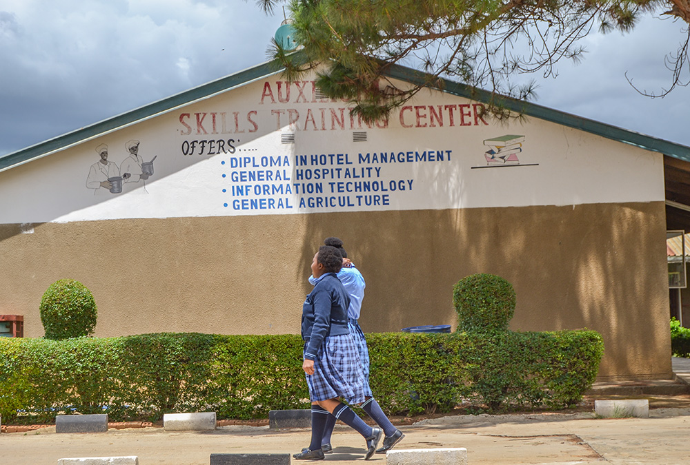 Young people walk by the Auxilium Skills Training Center in Makeni, Lusaka, Zambia. Along with the Home for Girls at Risk and the Open Community School, the center is part of City of Hope, run by the Salesian Sisters of St. John Bosco. (GSR photo/Derrick Silimina)