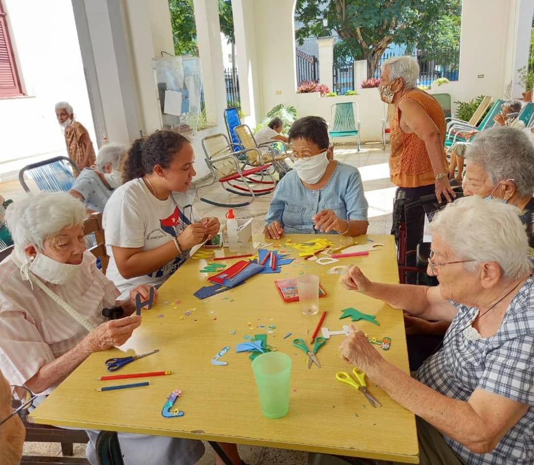 Sister Lara, in a white blouse, leads a craft activity with the women residents during her visit to the Siervas de San José Home for the Elderly in Havana, Cuba. (Courtesy of Siervas de San José Home for the Elderly)