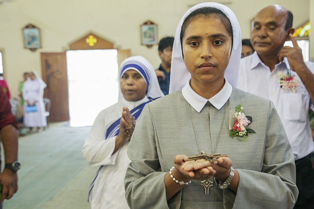 Vincentian Sr. Teagon Andre Maria receives a cross from Bishop Paul Ponen Kubi at St. Patrick's Cathedral Church on June 24 in Mymensingh, Bangladesh, during her vows as a Sister of Charity of St. Vincent de Paul. (GSR photo/Stephan Uttom Rozario)