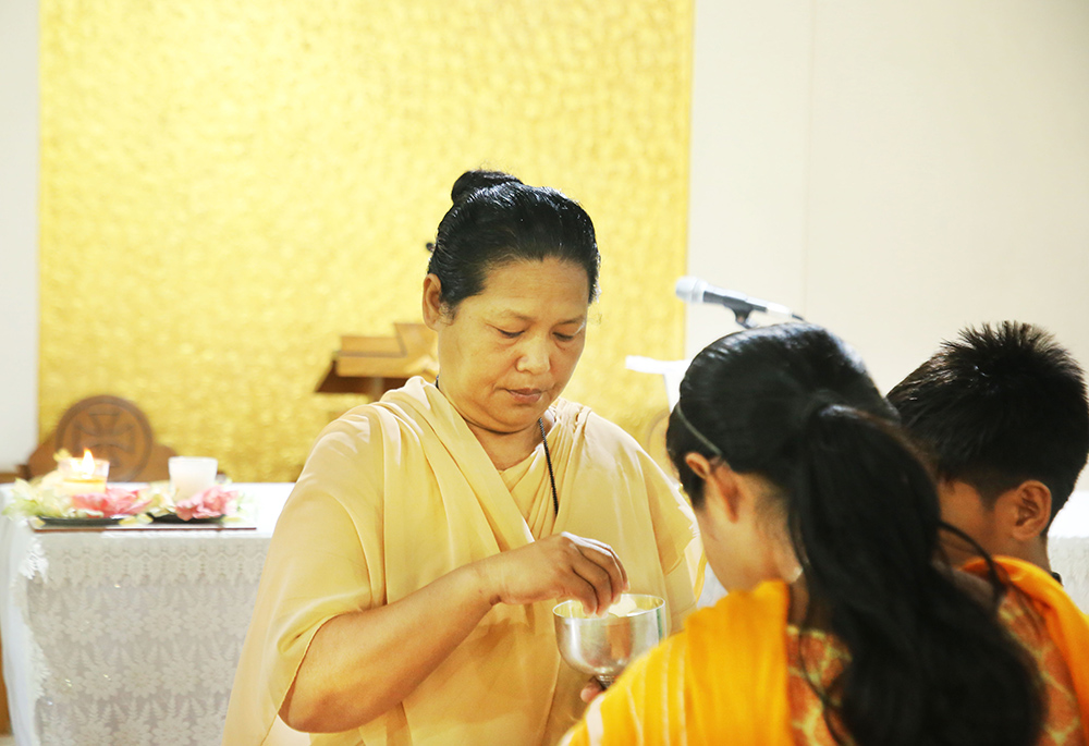 Our Lady of the Missions Sr. Rose Sulekha Chambugong serves the Eucharist during Mass. Chambugong's congregation established the first missionary-run school and hostel in the hilly Chittagong region. (Stephan Uttom Rozario)