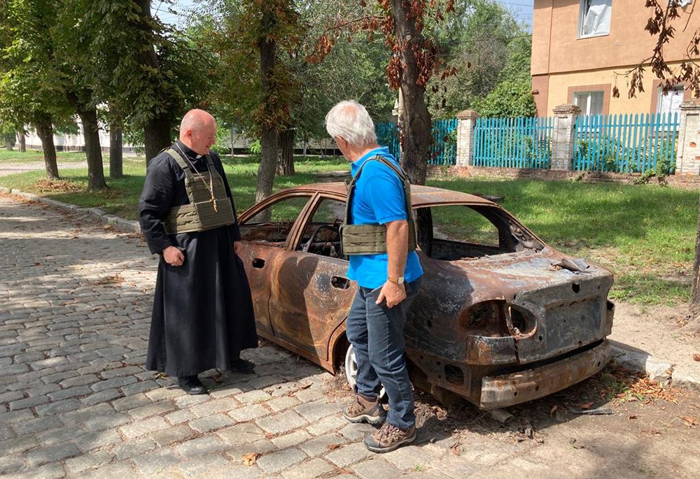 Auxiliary Bishop Jan Sobilo of Kharkiv-Zaporizhzhia, Ukraine, looks at a destroyed vehicle in in the summer of 2022 in the eastern Ukrainian region covered by the diocese. (OSV News photo/Courtesy of Jan Sobilo)