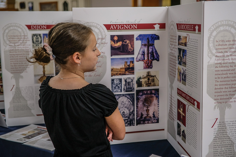 At Immaculate Conception Church in Clarksville, Tennessee, in July 2023, Giavana Hoefler, 10, looks over an exhibition created and designed by Blessed Carlo Acutis that explains every eucharistic miracle documented around the world. The 156-poster display has miracles listed across 20 countries and witnessed by multiple saints and beatified individuals. (OSV News/Tennessee Register/Katie Peterson)