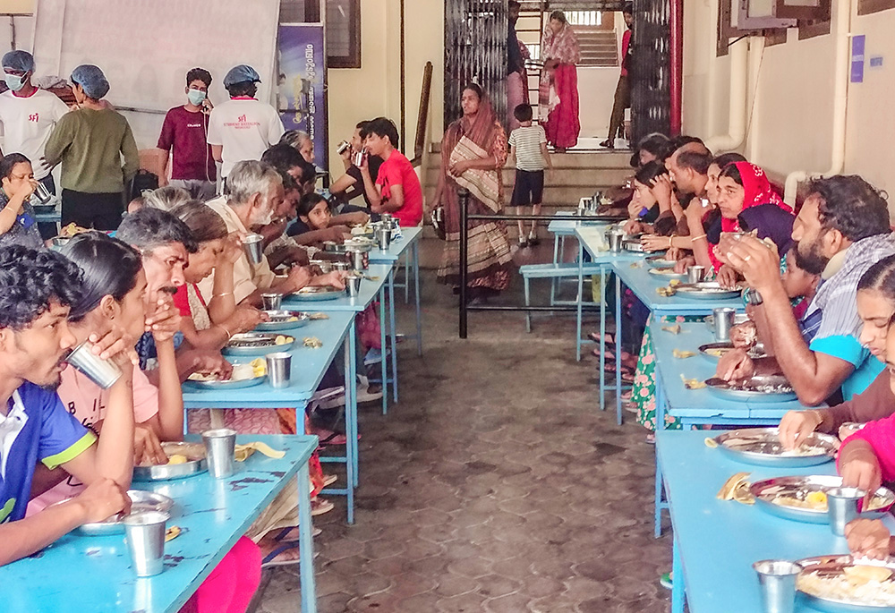 Residents of the De Paul relief camp, a church-based camp at Kalpetta, a town in the Wayanad district of Kerala, a southwestern Indian state, eat breakfast on Aug. 7. (Thomas Scaria)