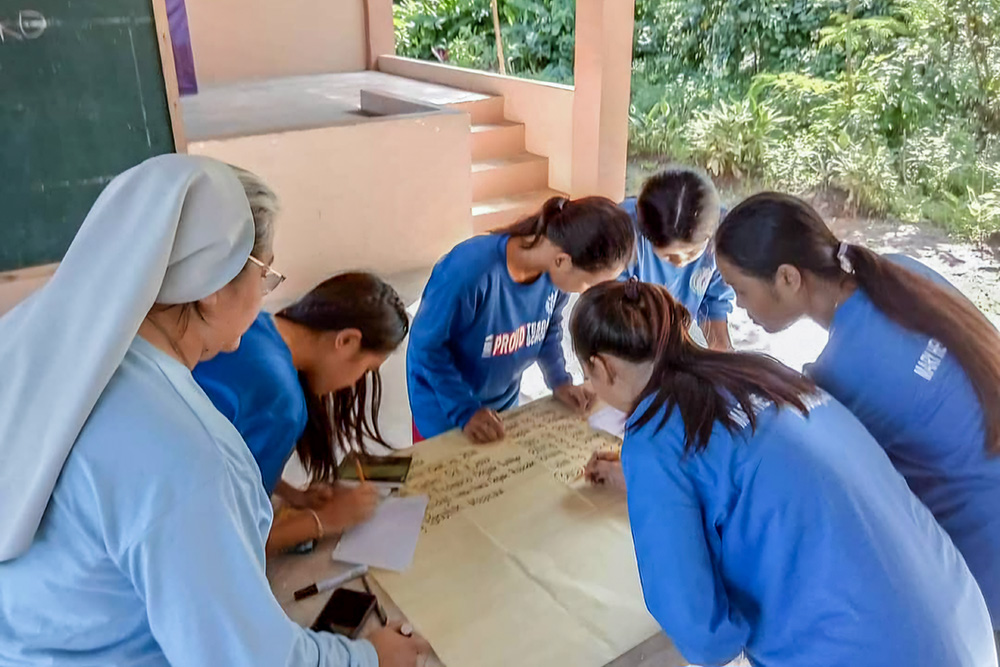 Sr. Ailyn Cayanan facilitates an agro-entrepreneurial session, coaching participants at Mary Help of Christians School - Mindoro Inc. in Calapan City, Philippines, to make their own business improvement plan. (Courtesy of Ailyn Cayanan)