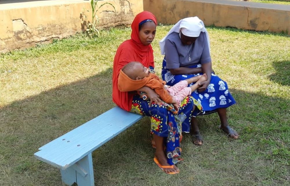 Sr. Felicitas Asoh prays with and counsels a woman and her son, Mohan.