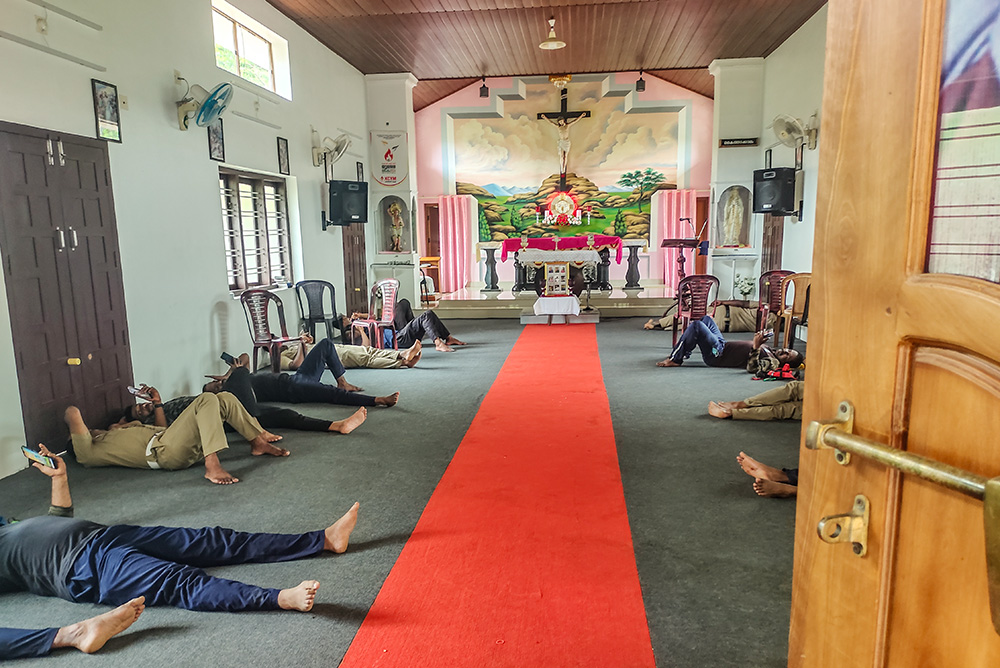 Rescue operators, including police and military personnel, rest after lunch inside St. Sebastian Church, Chooralmala, Wayanad, Kerala, southwestern India. (Thomas Scaria)