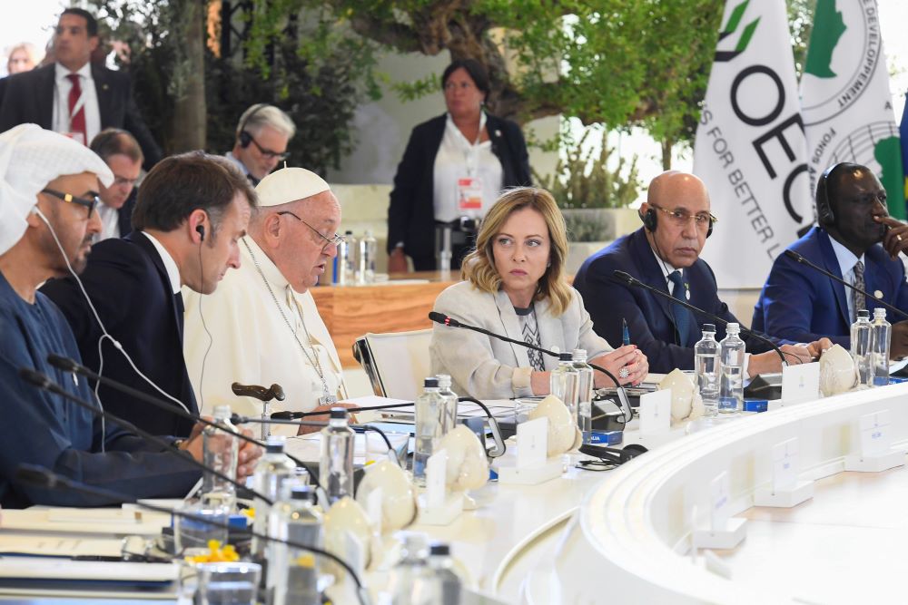 Italian Prime Minister Giorgia Meloni looks on as Pope Francis gives a speech.