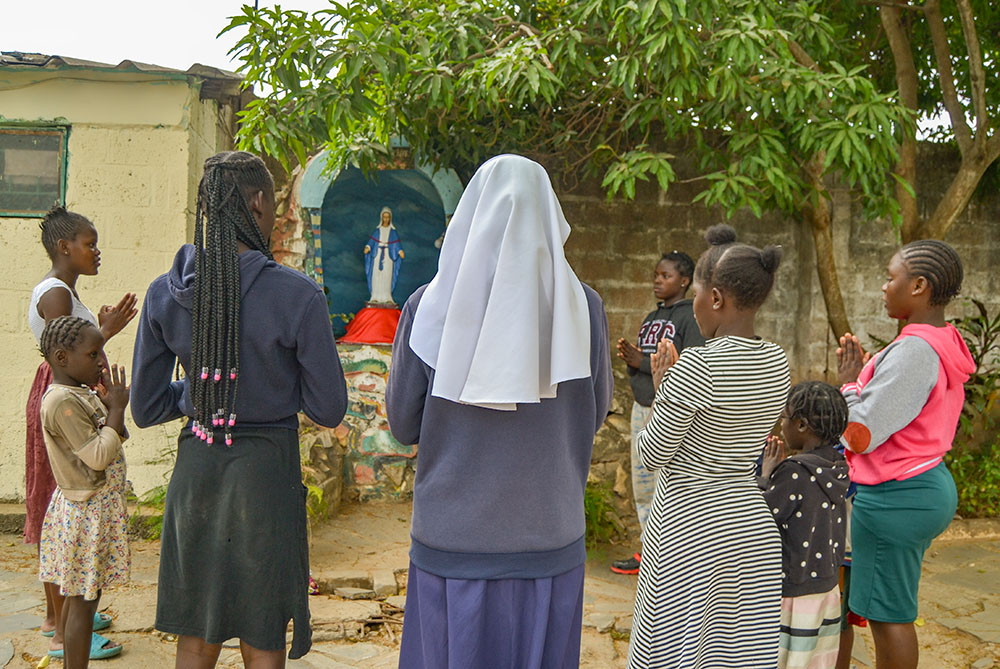 Immaculate Conception Sr. Theresa Kulandai and some orphaned girls gather to recite prayers at the main entrance of Home of Joy in Lusaka, Zambia. (Derrick Silimina)