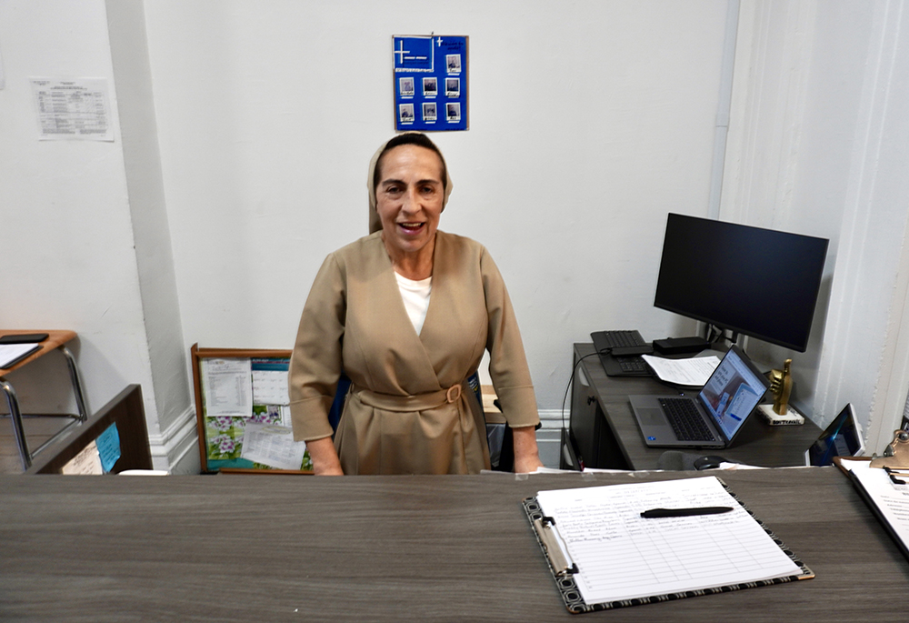 Sr. Martha Lopez is pictured working at the front desk of the resource fair sponsored by Catholic Charities of the Archdiocese New York, at St. Teresa's Church in Manhattan's Lower East Side, in July 2024. (NCR photo/Camillo Barone)