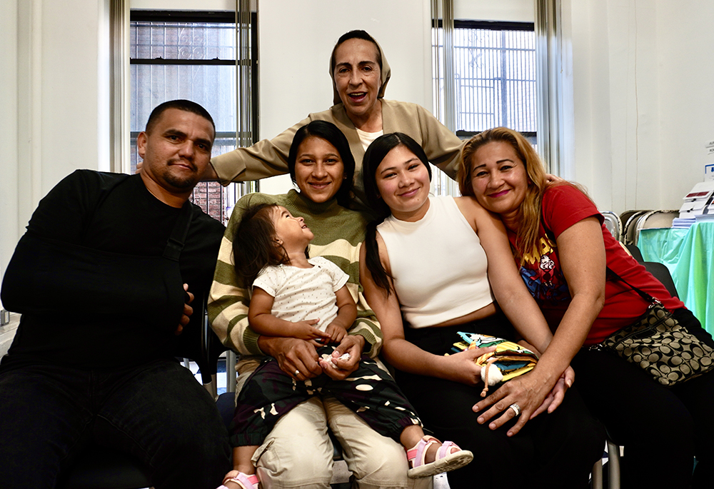 Venezuelan immigrants Carlos and Lisbeth Villamizar (far right), are pictured with their daughters Isis and Wuilmari, granddaughter Luciana, and Sr. Martha Lopez (top) at the resource fair sponsored by Catholic Charities of the Archdiocese of New York, at St. Teresa's Church in Manhattan's Lower East Side, in July 2024. (NCR photo/Camillo Barone)