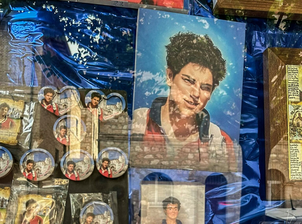 Carlo Acutis souvenirs are displayed in a shop window in Assisi, Italy, in June 2023. (RNS/Michael Di Giovine, CC BY)