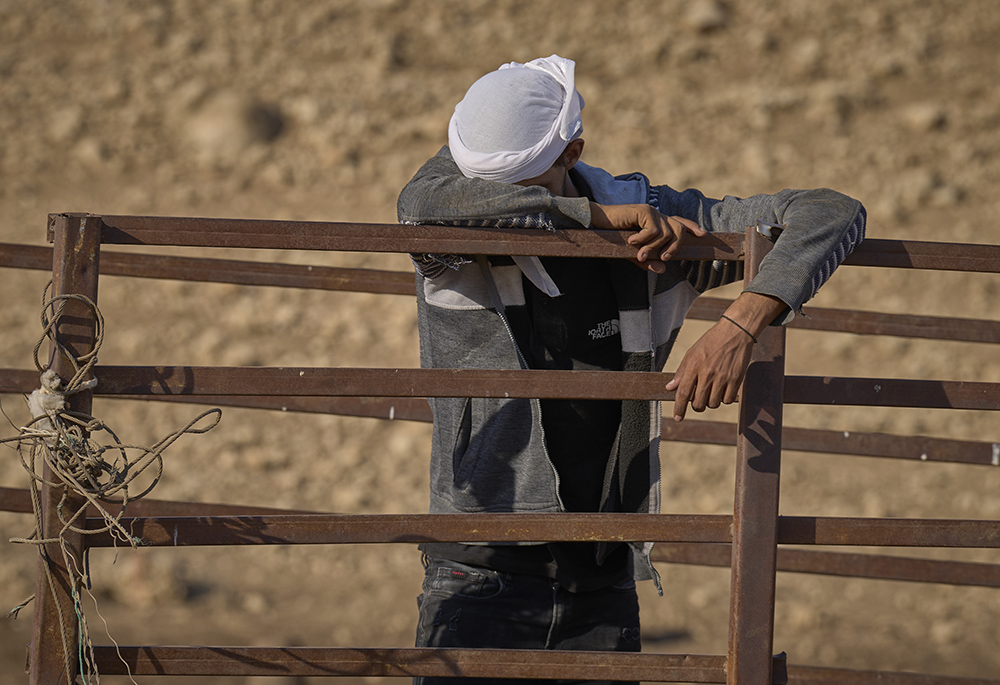 A Bedouin sheep farmer weeps in Uum Jamal, a small West Bank village, as he packs up his family's belongings Aug. 16. Israeli settlers harassed and threatened the community for a week, finally convincing them to leave. A Christian delegation from the U.S., which included Catholics, provided a protective presence as the farmers evacuated. (Life on Earth Pictures/Paul Jeffrey)