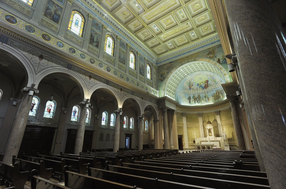 Vast, cavernous, and highly ornate sanctuary of empty church. 