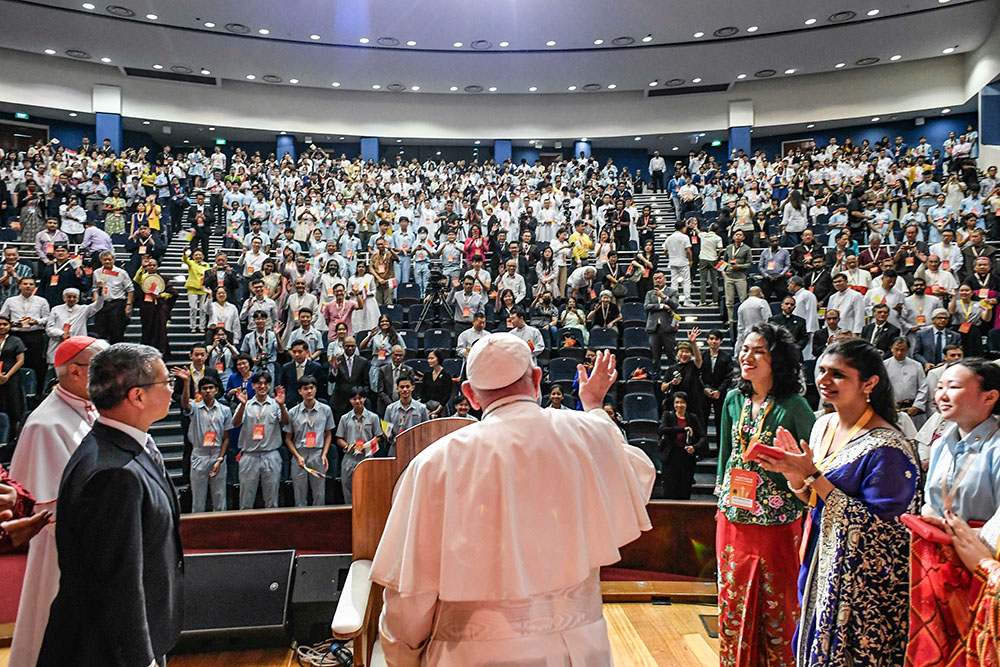 Pope Francis waves to young people gathered for a meeting on interreligious dialogue at the Catholic Junior College in Singapore Sept. 13. (CNS/Vatican Media)