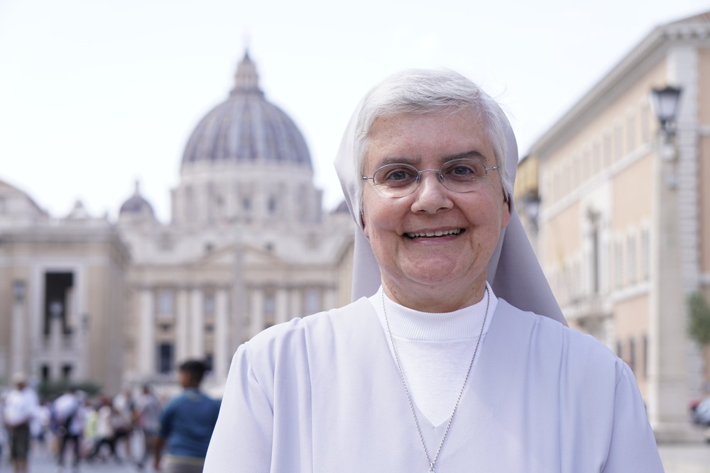 Sister Carneiro stands smiling, behind her, out of focus, is St. Peter's facade and dome.