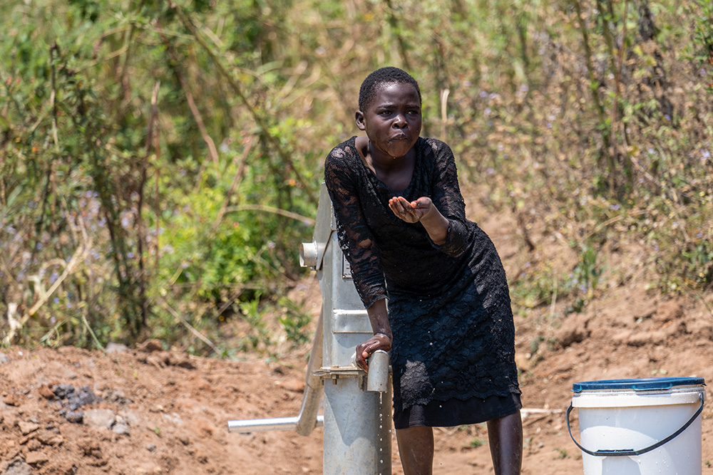 A young woman drinks from the installed water pump at Mphatso village in Malawi on Oct. 1, 2021. (Courtesy of Monica Ichife)