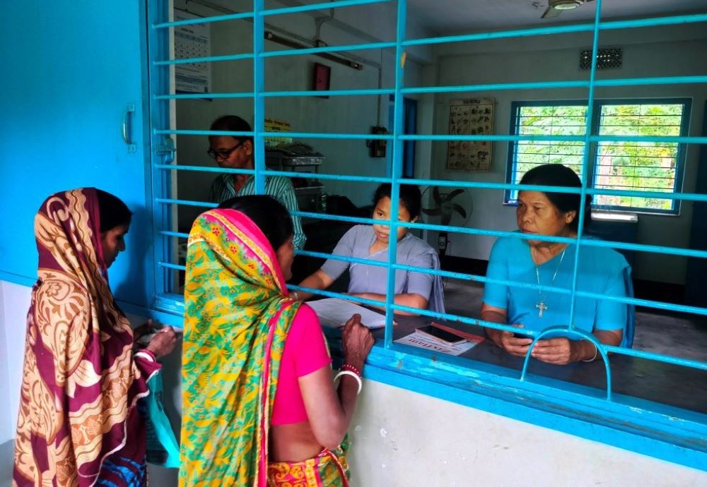 Holy Cross Sr. Thecla Dinila Nokrek, right, speaks with patients at the Holy Cross Health Education Centre.