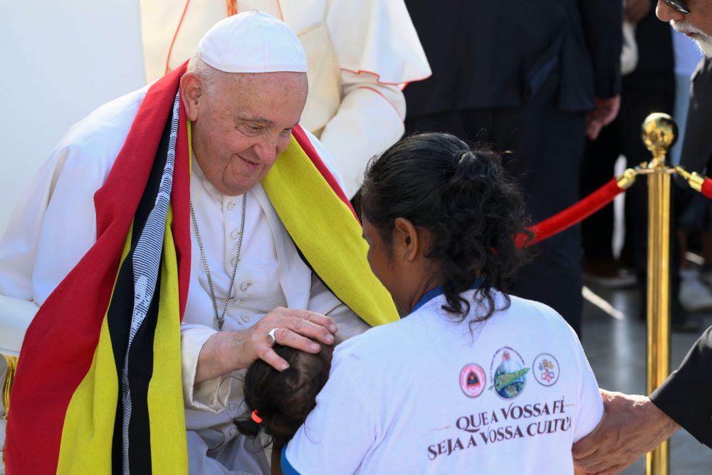 Pope Francis greets a woman and child during an outdoor Mass in Tasitolu, East Timor, Sept. 10. 